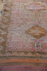 Distressed vintage Kurd runner pile detail with faded pink, orange, and beige hues.