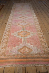 Distressed pile, woven kilim end, and fringes on a vintage Kurd rug runner.