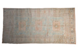Vintage distressed Oushak runner with oversized gul medallions in soft powder blue and dusty rose.