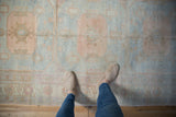 The soft, low-pile texture and sun-faded pastel medallions of a distressed Oushak rug runner.
