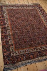 Close-up of antique Persian Afshar rug's allover boteh pattern in madder red and navy.