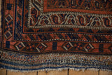Textured flatweave kilim and worn, multicolored fringe on an antique Afshar rug corner.