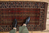 Antique Belouch rug shown to scale, detailing the parallel vine pattern and warm, earthy tones.