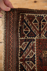 Tattered side showing the reciprocating wave design on the plain weave end of an antique Belouch rug.