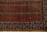 Detailed view of the running channels, geometric border, and storied, low-pile texture of an antique Belouch rug.