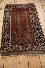 Full view of an antique Belouch rug showing its unusual parallel channel field.