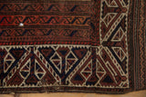 A small hole showing the foundation amidst the worn, hand-knotted pile of an antique Belouch rug.