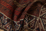 Finely knotted texture and detailed geometric patterns shown on a draped antique Persian Belouch rug.