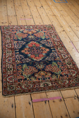 Hand-knotted Qazvin rug detail showing indigo field with cherry red rose bouquet, intricate vinery.