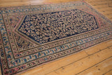 Corner of vintage Persian Hamadan rug with blush pink, navy, and dusty blue floral motifs.