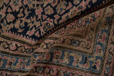 Textured pile of a vintage Hamadan rug, revealing traditional patterns in navy, pink, and beige tones.