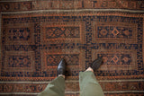 Overhead view showing the low pile and intricate multi-panel design of a vintage Belouch rug.