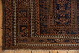Reciprocating pawn and wave motif borders on a vintage Belouch rug corner with dark selvage.