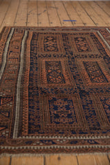 Angled view of the time-softened pile and panel design on a vintage Belouch rug.