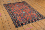 Corner of vintage Persian Lilihan rug, displaying navy border with floral motifs and localized wear.