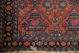 Corner of Lilihan rug shows brick red field, navy border, and exposed foundation.