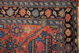 Vintage Lilihan rug corner: brick red field, navy blue border, exposed foundation, discolored area.