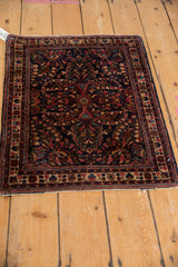 Vintage Sarouk rug left edge, dark blue field with raspberry floral sprays and ivory border.