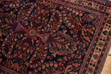 Detail of vintage Sarouk rug showcasing rare dark blue ground and raspberry floral motifs.