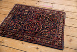 Intact side cord selvage and intricate floral borders of a vintage Sarouk rug.