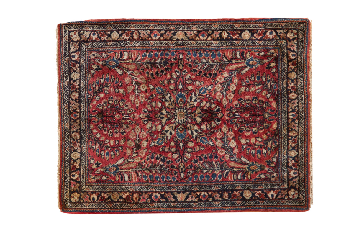 Vintage Sarouk square rug featuring floral bouquets on a cherry red field with a dark navy blue border.