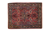 Vintage Sarouk square rug featuring floral bouquets on a cherry red field with a dark navy blue border.
