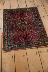 An angled look at a vintage Persian Sarouk rug, showing the dense floral bouquets on a red ground.