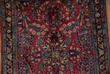 Even pile texture of a vintage Sarouk rug showing classic red, blue, and ivory floral bouquets.