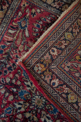 Original side cord selvage and detailed navy floral border of a vintage Sarouk rug.