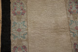 Even pile texture of the beige field beside a charcoal edge and dusty rose floral border.