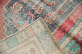 Worn vintage Oushak rug pile with pac-man floral motif, showing its woven foundation and selvage.