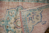 Hand-knotted Oushak rug close-up, showing distressed dusty rose pile, foundation, and selvage.
