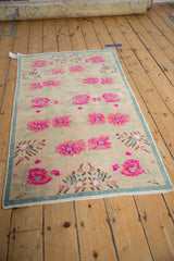 Textured pink floral motifs and seafoam border on this distressed Oushak rug's corner.