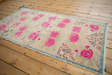 Distressed pile of the vintage Oushak rug revealing pink blossoms and faint foundation.