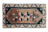 Distressed vintage Oushak rug featuring central stylized floral motifs in beige, copper, and deep teal. 2'5