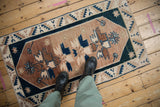 Vintage distressed Oushak rug section with copper, dusty teal, and beige geometric floral motifs.