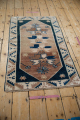 Distressed vintage Oushak rug showing copper, beige, and blue floral geometric pattern with even wear.
