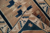 Folded corner of a distressed Oushak rug, showing low pile, geometric blue, and beige patterns.