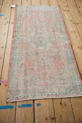 Vintage Oushak runner detail showcasing distressed pile, pale tangerine and seafoam floral motifs.