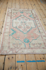 Angled view of a distressed Turkish Oushak showing its overall pattern and time-softened texture.