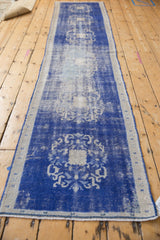 Distressed cobalt blue Oushak runner detail, worn floral arabesques and visible foundation texture.