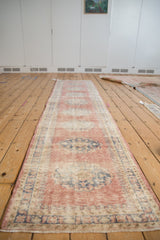 Vintage distressed Oushak runner with faded cochineal blush and cobalt medallions.