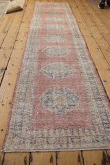 Pale blush distressed Oushak runner with worn knot heads, dusty cobalt pawn border.