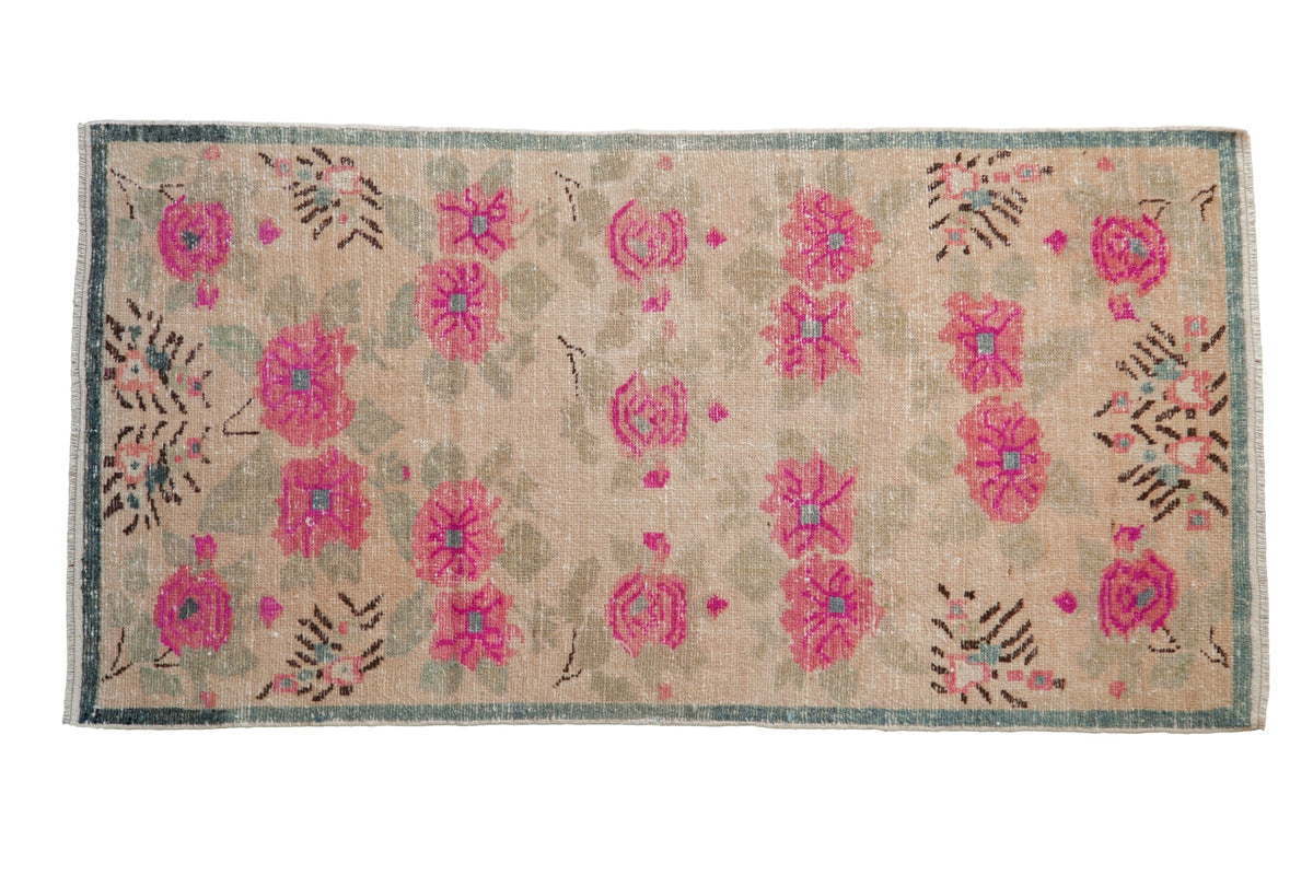 Distressed vintage Oushak runner features large fuchsia floral bouquets on a nuanced ivory ground.