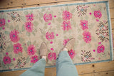 Full field of vintage distressed Oushak runner with fuchsia floral blossoms and finned leaves.
