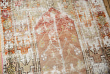 Distressed Oushak rug detail with exposed foundation, dusty cherry red, and ivory stylized florals.