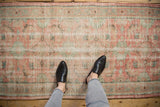 Distressed vintage Oushak runner texture with blush, mint, and ivory Herati motif.