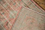 Distressed Oushak runner pile in blush, mint, ivory, folded to reveal wear and foundation.