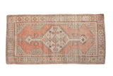Distressed vintage Oushak runner with stepped medallion, faded cantaloupe, mint green, and ivory.