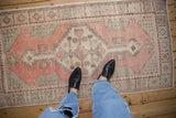 Distressed vintage Oushak runner, with even wear revealing cantaloupe, dusty rose, and mint.